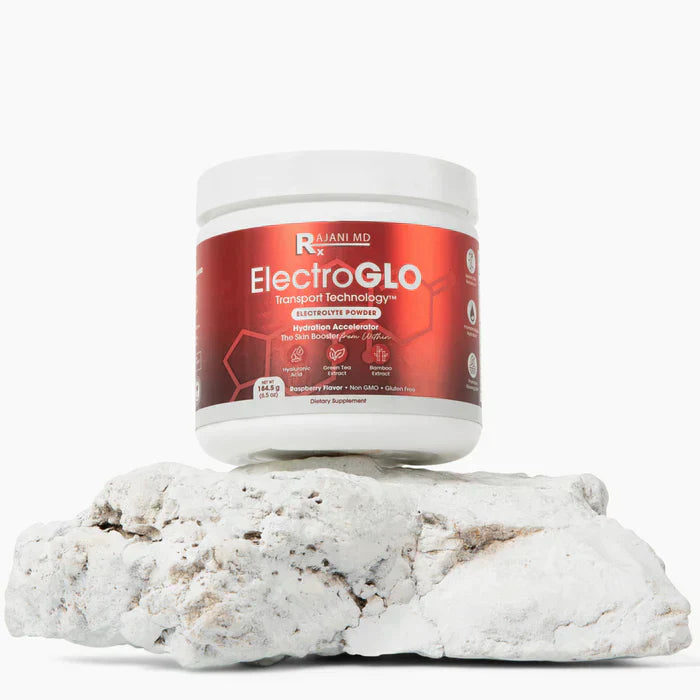 RajaniMD ElectroGLO electrolyte powder container displayed on white rock surface.