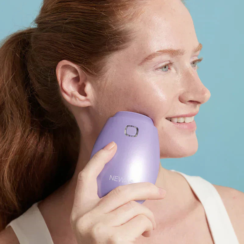 Woman using the NEWA+ Cordless RF Wrinkle Reduction Device in Lavender on her cheek during an at-home skin-tightening treatment.