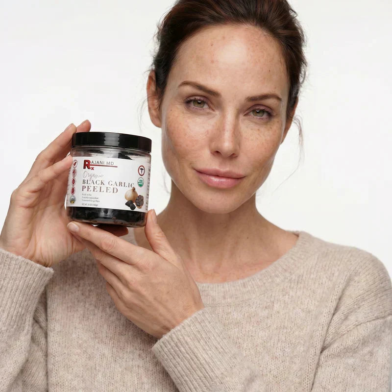 Woman holding a jar of Rajani MD 100% Organic Black Garlic, an aged garlic product rich in antioxidants and S-Allyl Cysteine.