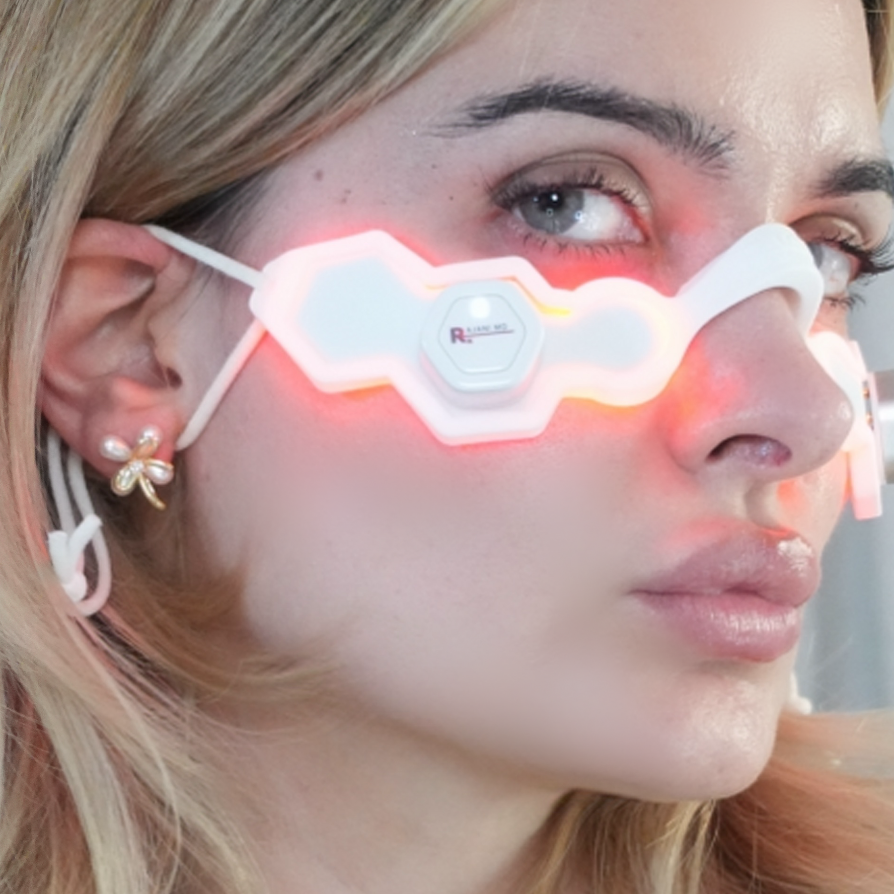 Person wearing a red light therapy device on their face