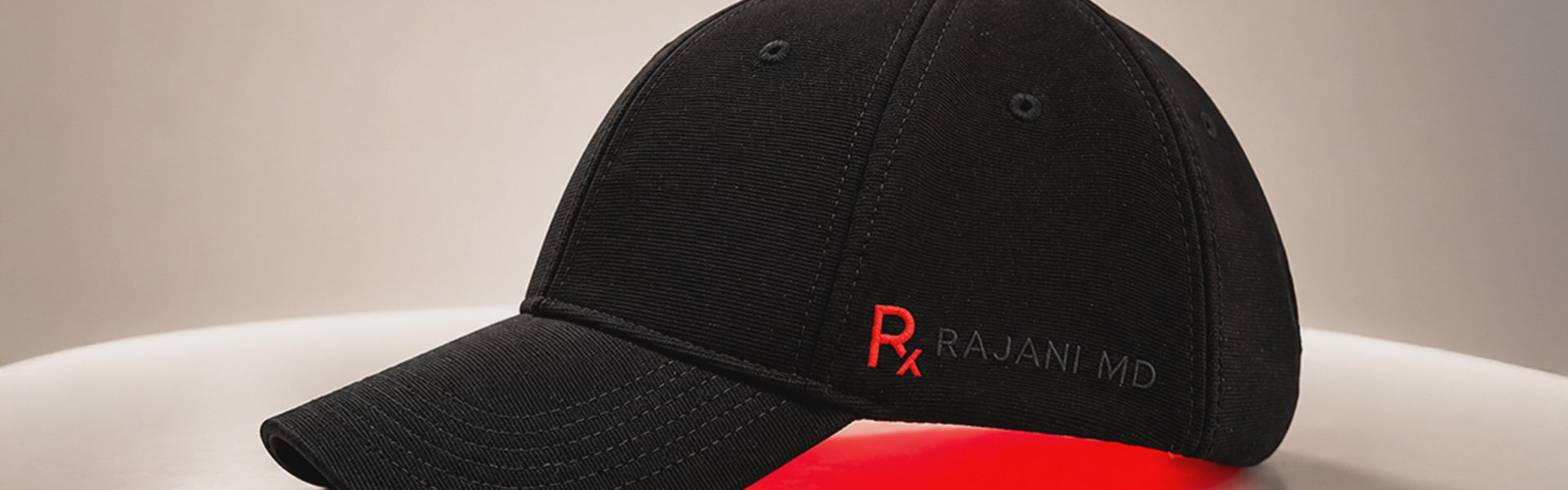 A video of photos of the Rajani MD PlasmaGLO Hair+ Cap from different angles, illuminated in red and blue light.
