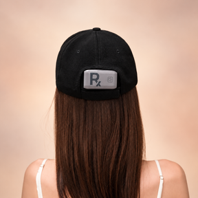 Rear view of a woman wearing the Rajani MD PlasmaGLO™ Hair+ Cap, showing the controller at the back.