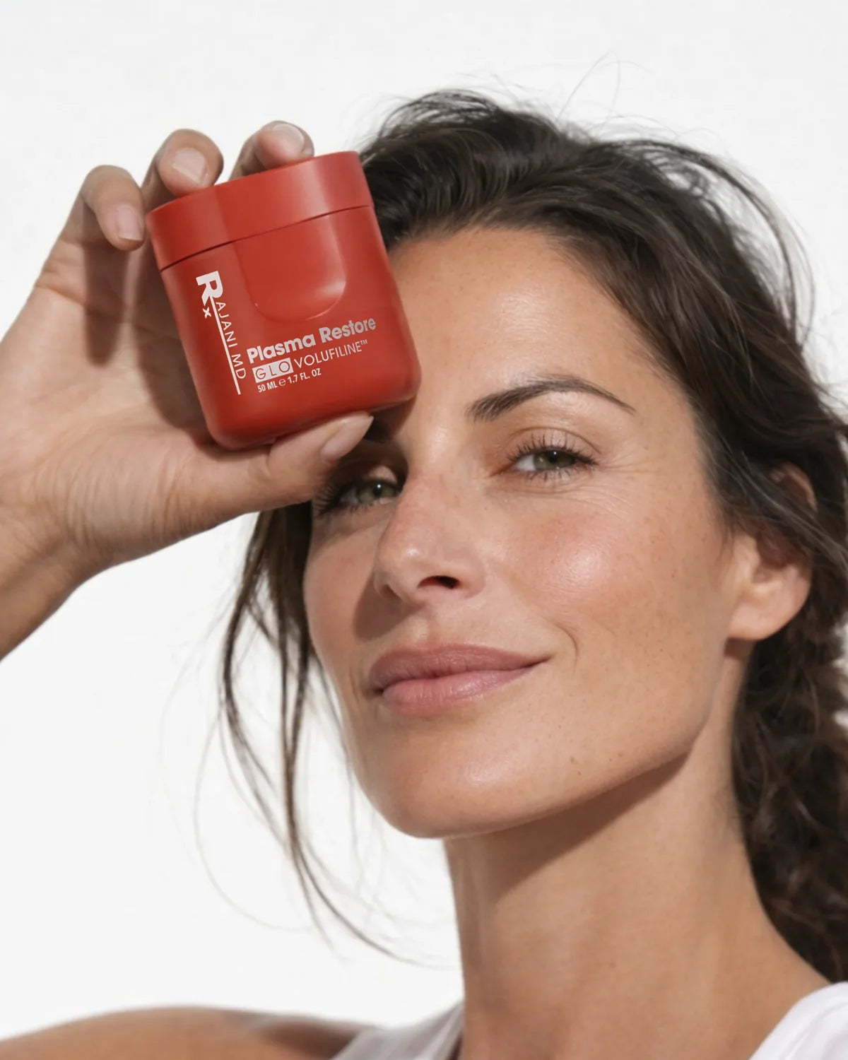 Woman holding the red Volufiline jar at her temple